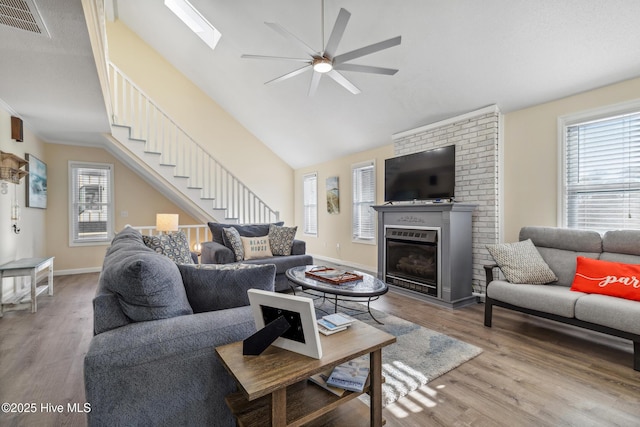 living room featuring hardwood / wood-style flooring, ceiling fan, and vaulted ceiling