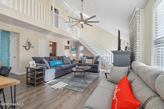 living room featuring a high ceiling, hardwood / wood-style floors, and ceiling fan