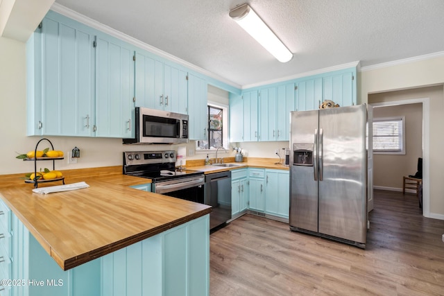 kitchen featuring appliances with stainless steel finishes, blue cabinetry, sink, and kitchen peninsula