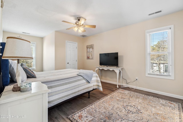 bedroom featuring dark wood-type flooring, ceiling fan, and multiple windows