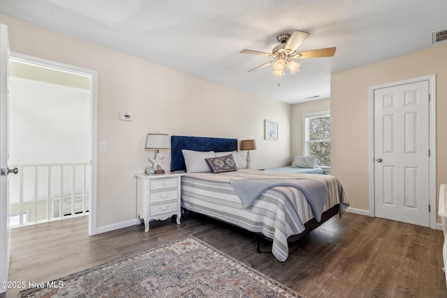 bedroom with dark hardwood / wood-style floors and ceiling fan