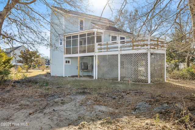 rear view of house with a sunroom and a deck