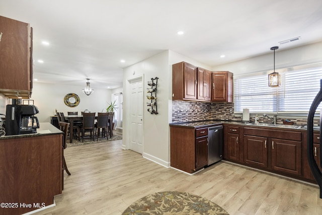 kitchen with pendant lighting, tasteful backsplash, sink, stainless steel dishwasher, and light hardwood / wood-style flooring