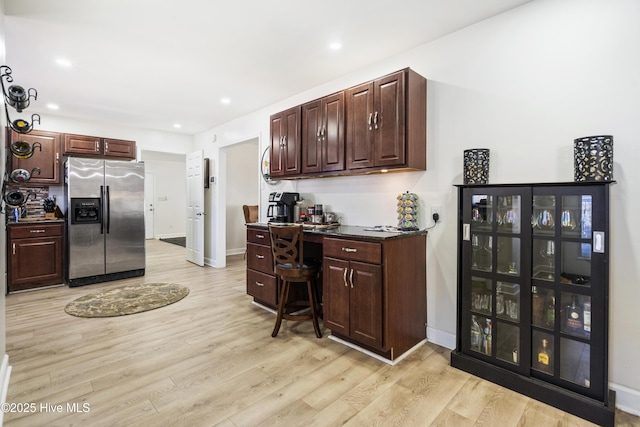 kitchen with light hardwood / wood-style flooring and stainless steel fridge with ice dispenser