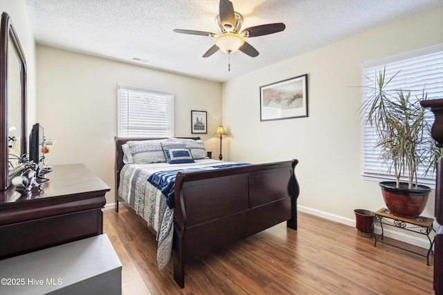 bedroom featuring hardwood / wood-style floors, a textured ceiling, and ceiling fan