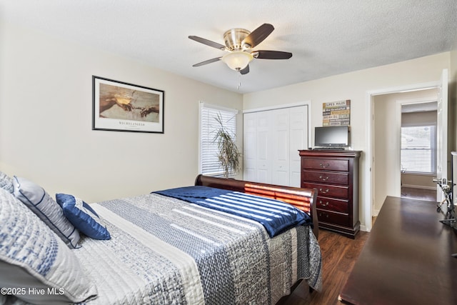 bedroom featuring a textured ceiling, a closet, ceiling fan, and dark hardwood / wood-style flooring