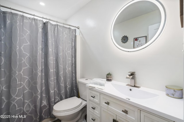 bathroom with toilet, vanity, and a shower with curtain