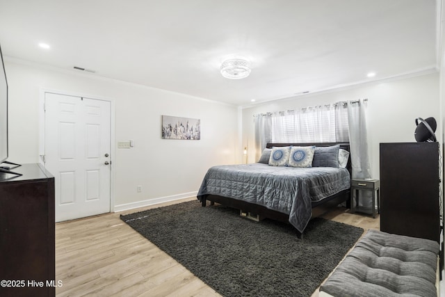 bedroom with light hardwood / wood-style floors and crown molding