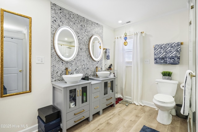 bathroom featuring hardwood / wood-style flooring, ornamental molding, toilet, vanity, and decorative backsplash