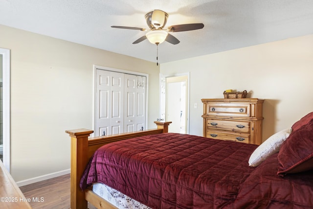 bedroom with ceiling fan, a textured ceiling, hardwood / wood-style flooring, and a closet