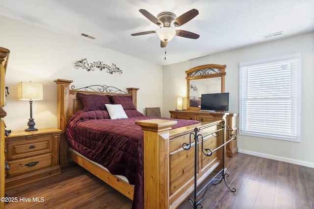 bedroom featuring ceiling fan, dark wood-type flooring, and multiple windows