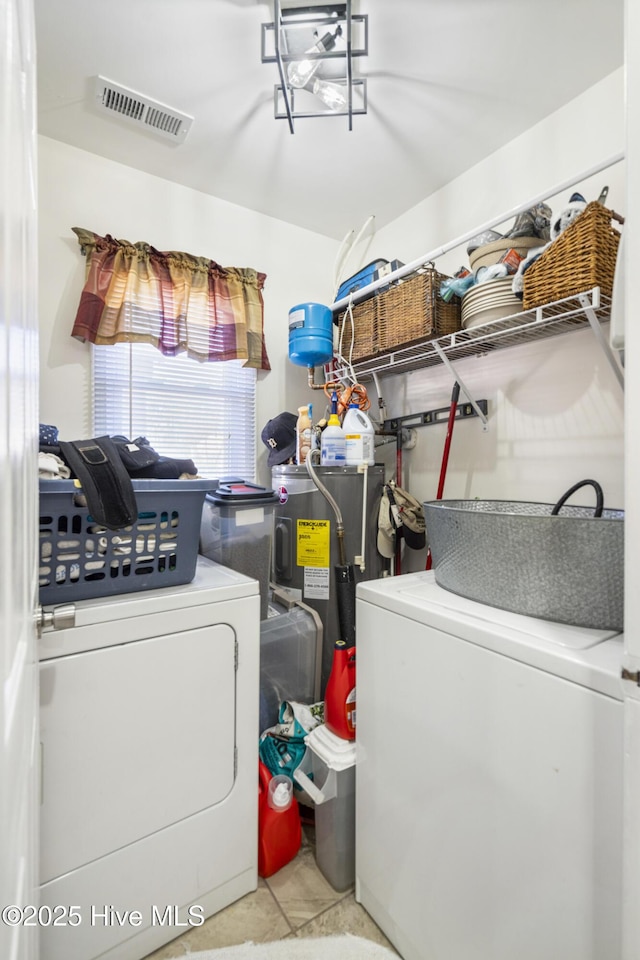 laundry room with light tile patterned floors and electric water heater