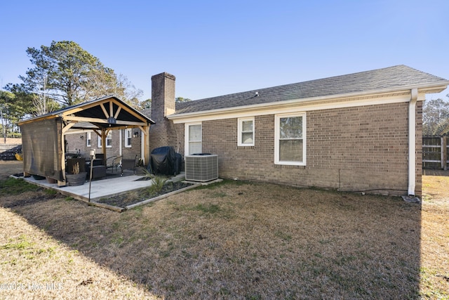 back of property with a lawn, a gazebo, a patio area, and central AC