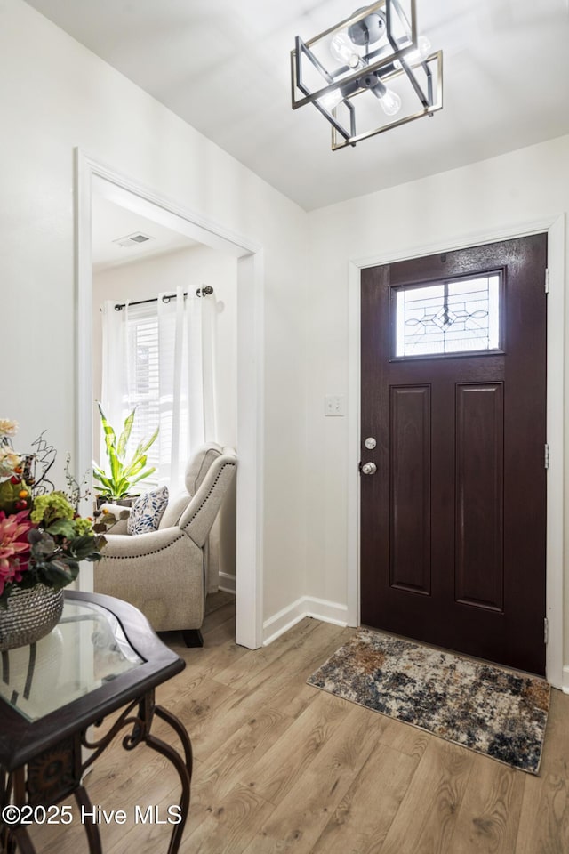 entryway featuring a chandelier and light hardwood / wood-style flooring