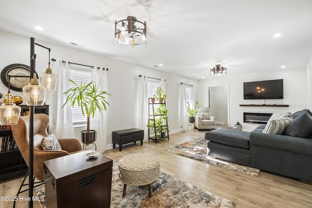 living room featuring light hardwood / wood-style floors and an inviting chandelier