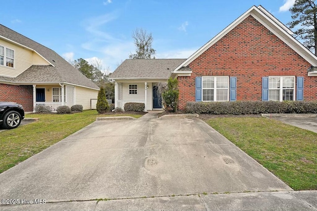 view of front of property with covered porch, a front yard, and brick siding