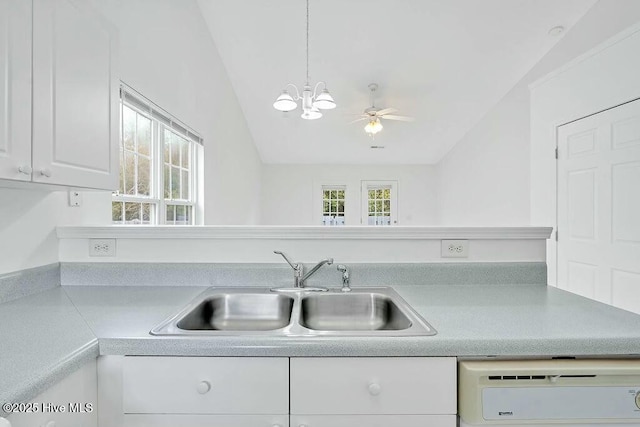 kitchen featuring dishwashing machine, a sink, light countertops, and a healthy amount of sunlight