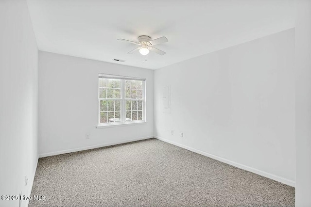 unfurnished room with a ceiling fan, visible vents, and baseboards