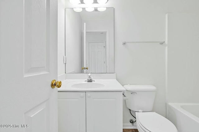 bathroom featuring a tub to relax in, vanity, and toilet