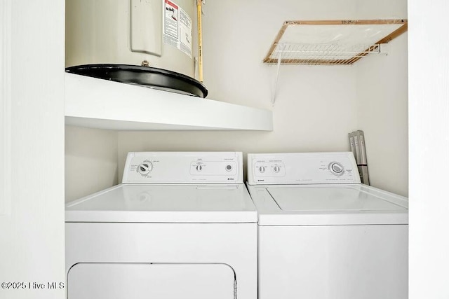 clothes washing area featuring water heater and washing machine and clothes dryer