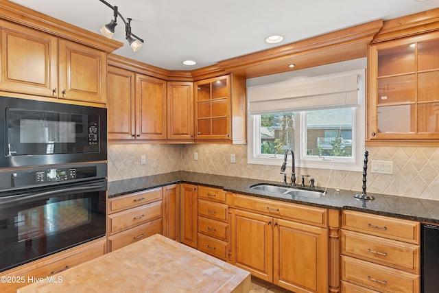 kitchen featuring sink, dark stone countertops, decorative backsplash, and black appliances