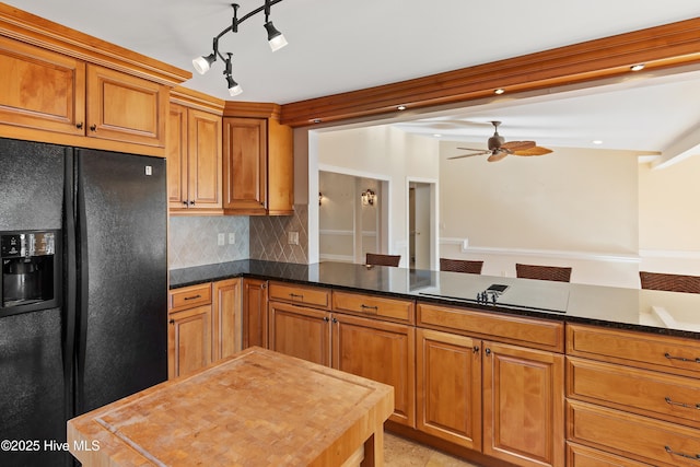 kitchen featuring tasteful backsplash, ceiling fan, kitchen peninsula, and black appliances