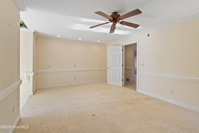 empty room featuring crown molding, light colored carpet, and ceiling fan