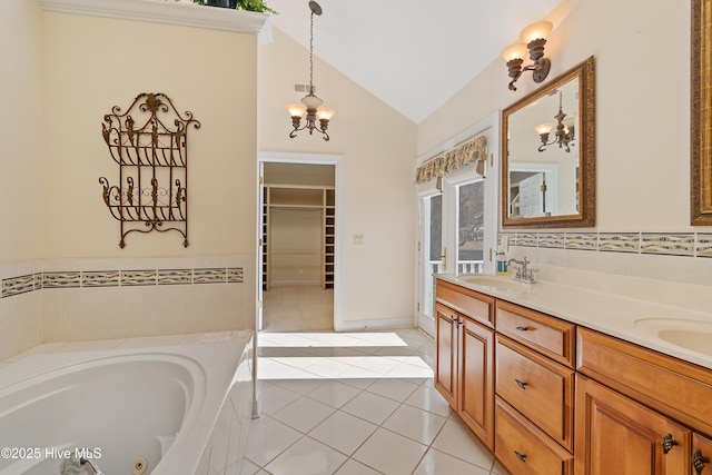 bathroom featuring lofted ceiling, a chandelier, vanity, tiled bath, and tile patterned flooring