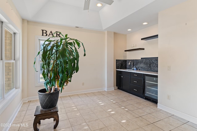 kitchen with tasteful backsplash, sink, wine cooler, light tile patterned floors, and ceiling fan