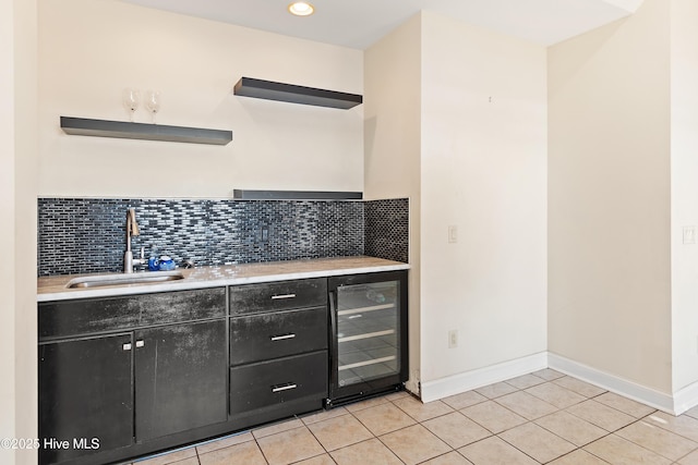 kitchen with sink, backsplash, beverage cooler, and light tile patterned floors