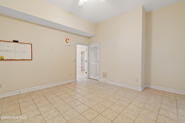 empty room with ceiling fan and light tile patterned floors