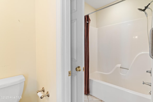 bathroom featuring tile patterned floors, toilet, and shower / bath combo with shower curtain