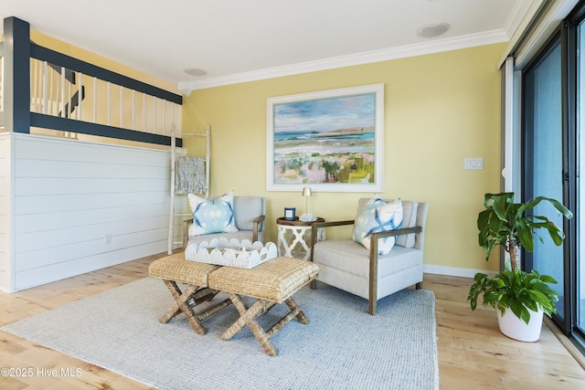 living area with crown molding and hardwood / wood-style floors