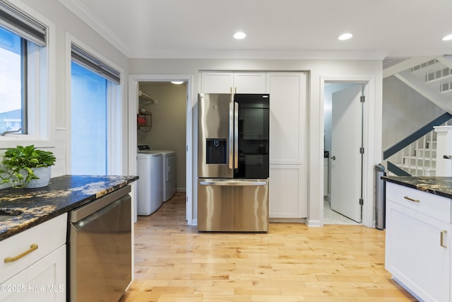 kitchen featuring dishwashing machine, stainless steel fridge, independent washer and dryer, white cabinets, and dark stone counters