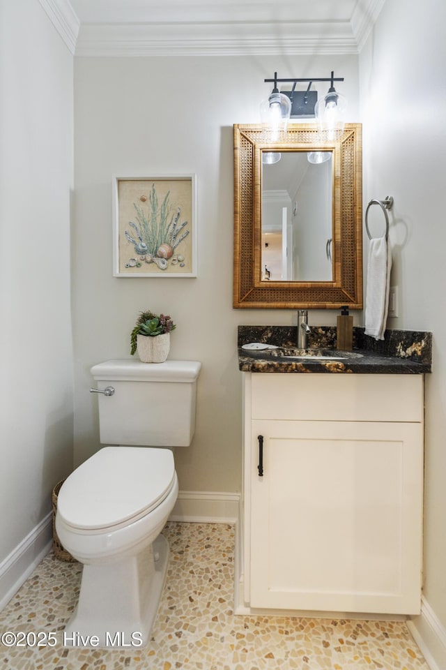 bathroom featuring vanity, crown molding, and toilet