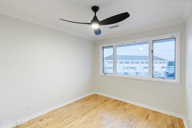 empty room featuring hardwood / wood-style flooring, ornamental molding, and ceiling fan