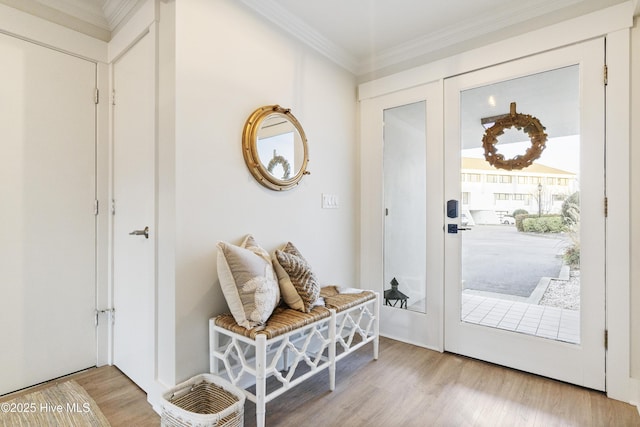 entryway with ornamental molding and light wood-type flooring