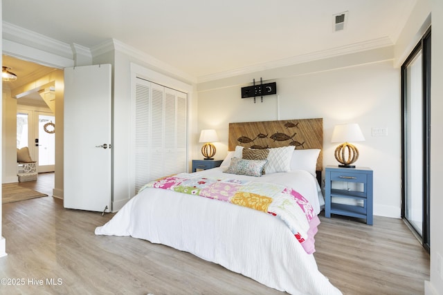 bedroom featuring ornamental molding, light hardwood / wood-style flooring, and a closet