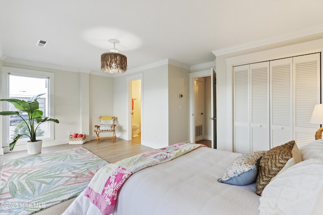 bedroom featuring crown molding, light hardwood / wood-style floors, and a closet