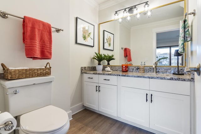 bathroom featuring vanity, crown molding, wood-type flooring, and toilet