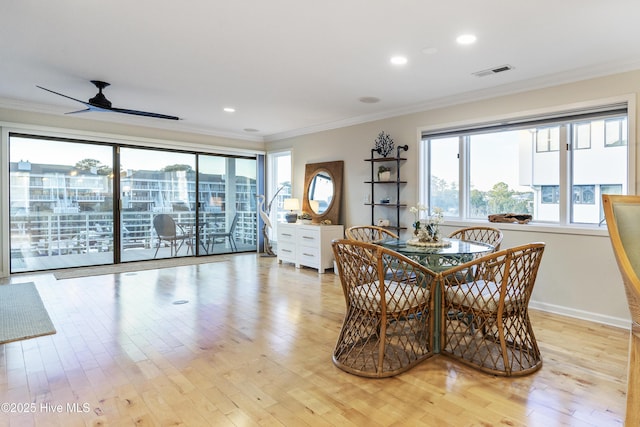 dining space featuring ceiling fan, ornamental molding, and light hardwood / wood-style floors