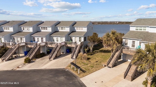 view of front facade featuring a carport, a residential view, concrete driveway, and stairs