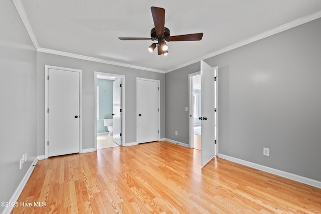 unfurnished bedroom featuring crown molding, light wood-type flooring, ensuite bath, and ceiling fan