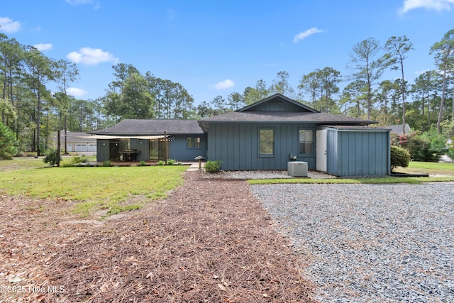 ranch-style home featuring central AC unit and a front yard