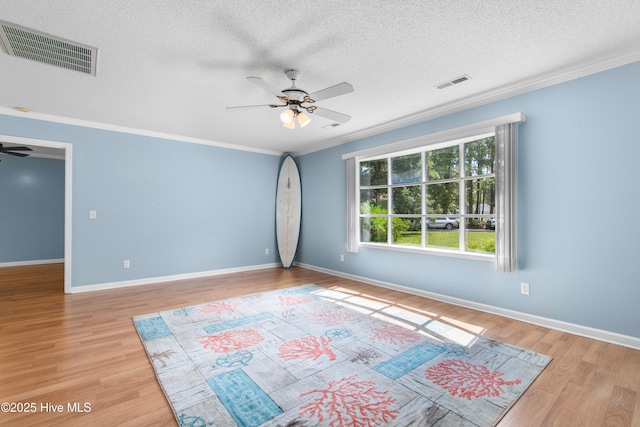 spare room with ceiling fan, crown molding, light hardwood / wood-style floors, and a textured ceiling