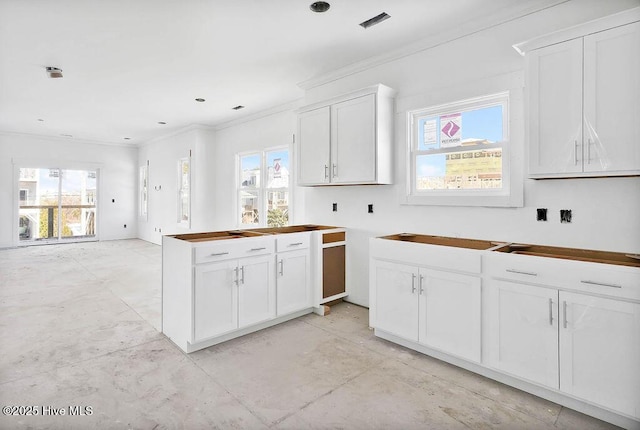 kitchen with ornamental molding and white cabinets