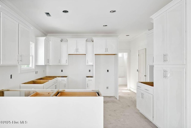 kitchen featuring white cabinetry, crown molding, and a center island