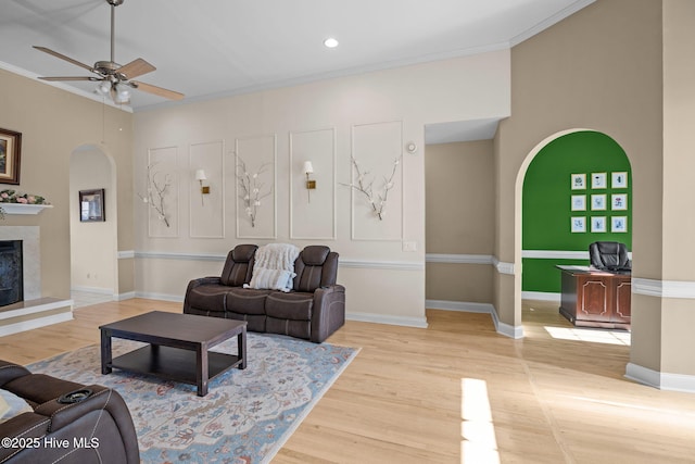 living room with ornamental molding, a fireplace, and light hardwood / wood-style floors