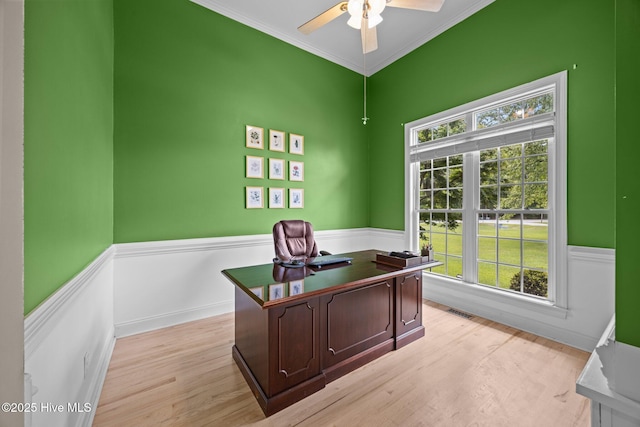 home office featuring ceiling fan, plenty of natural light, light wood-style floors, and wainscoting