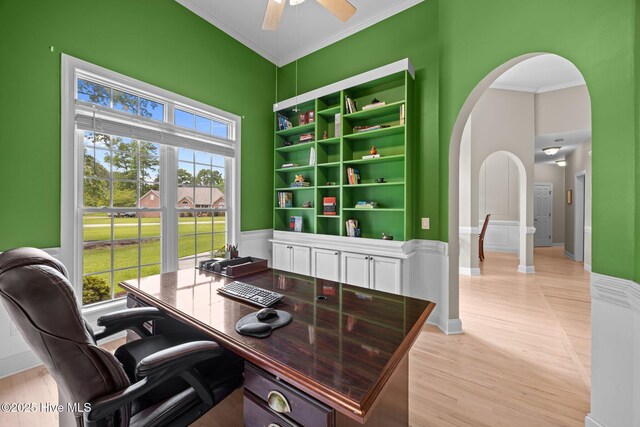 office with ornamental molding, light wood finished floors, arched walkways, and a ceiling fan